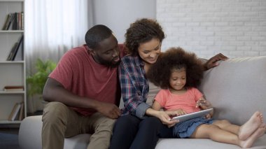Onların küçük kızı öğrenme eğitim uygulaması tablet izlerken anne