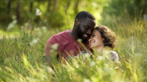 Casal Multirracial Rindo Conversando Enquanto Deitado Grama Encontro Livre — Fotografia de Stock