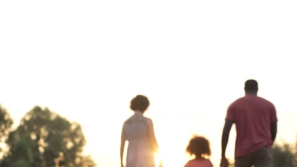 Happy family walking in sunset, bright future for loving parents and child