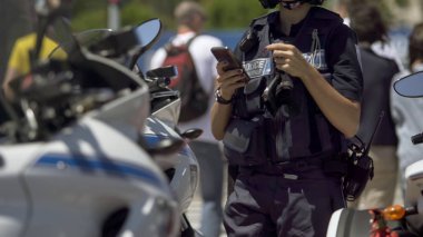 Kadın polis motosiklet yanında duran, hareket eden telefon görev kontrol memuru