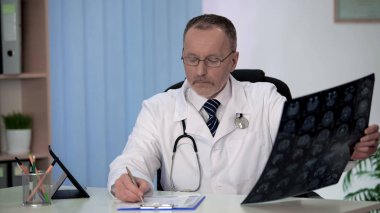 Deneyimli nörolog dikkatle inceleyerek beyin MRI, notes formunda yapma