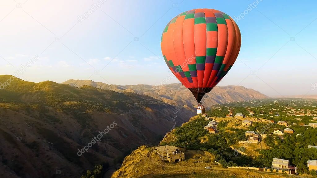 Beautiful hot air balloon flying over mountain village, Armenia aerial view