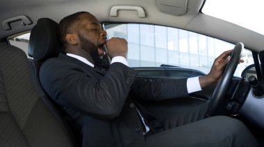 Esneme araba, overworked işadamı sürüş araba, tehlike yorgun siyah adam