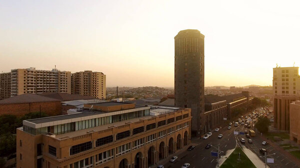 Золотой час в Ереване, вид с воздуха на транспортные средства, движущиеся возле мэрии, городской пейзаж
