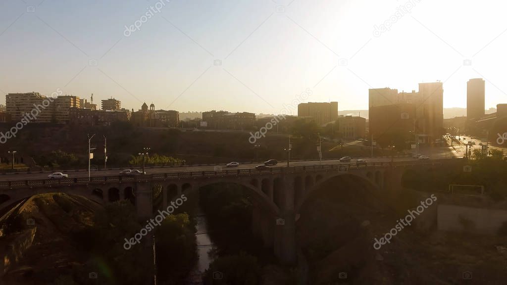 Automobiles crossing Victory bridge in Yerevan, travel to Armenia, golden hour