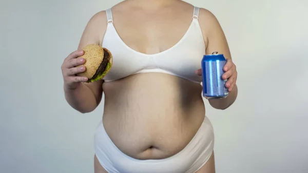 超重模型在内衣持有汉堡和苏打 垃圾食品导致肥胖 — 图库照片