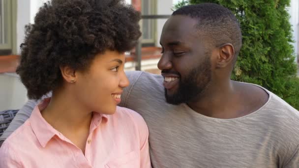 若い男と女聞き入った カフェ ガーデン 入札関係のロマンチックなデート — ストック動画