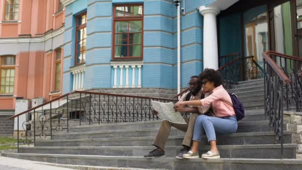 Estudiantes Universitarios Mirando Mapa Sentados Las Escaleras Haciendo Turismo — Vídeos de Stock