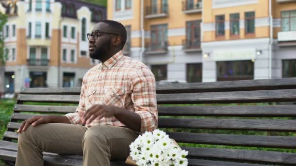 Nervös Ung Man Väntar Flicka Sitter Parkbänk Med Blommor Blinda — Stockvideo