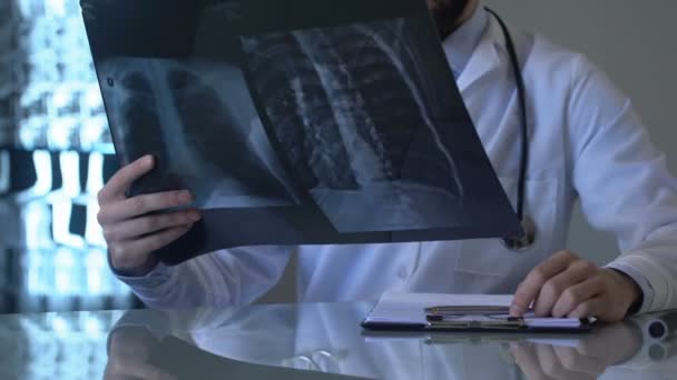 Pneumologista Masculino Que Olha Para Radiografia Dos Pulmões Escreve Observações — Vídeo de Stock