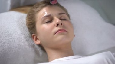 Güzellik Salonu nemlendirici maske kız, kadınlık yüzüne koydu işçi