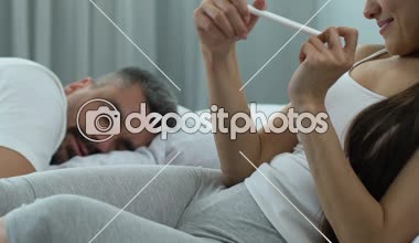 Karısı gösterilen koca pozitif gebelik testi, mutlu aile çift, ebeveynlik