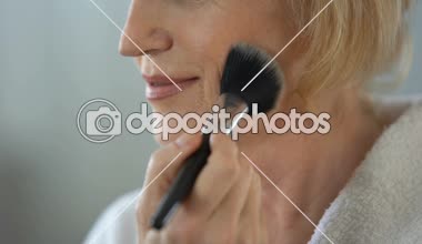 Olgun kadın yüz pudrası makyaj fırça ile uygulama için tarih, güzellik hazırlama