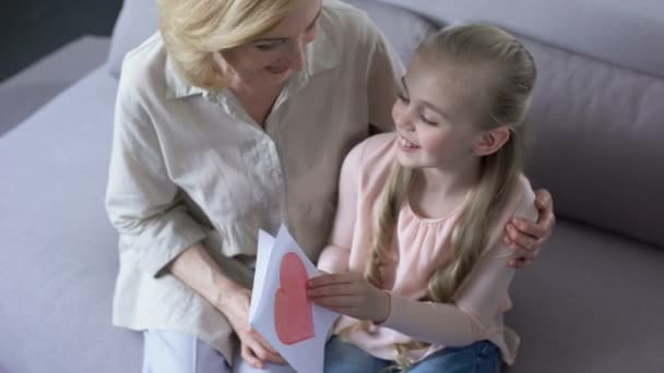 Joyful Kvinnliga Barnbarn Visar Handgjorda Gratulationskort Hennes Mormor Presentera — Stockvideo