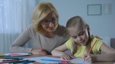Bakım şirin torunu ile renkli kalemler boyama bakarak kadın emekli