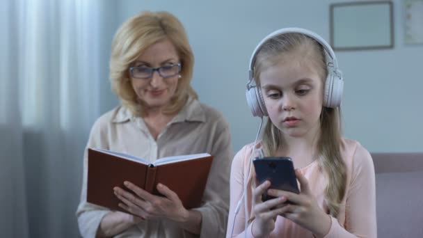Κορίτσι Ακουστικά Ακούτε Μουσική Και Γιαγιά Αλφαβητάριον Χάσμα Των Γενεών — Αρχείο Βίντεο