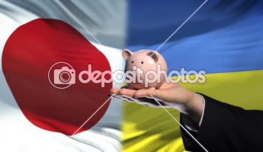 Japonya yatırım Ukrayna, el para servet içinde bayrak arka plan üzerine koyarak.