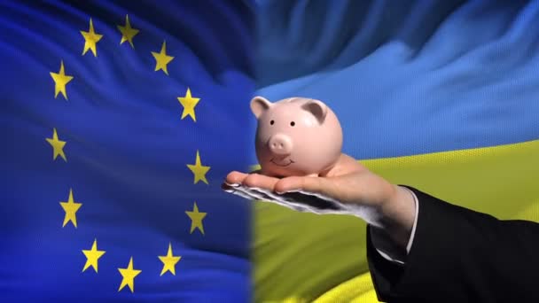 Investitionen Der Ukraine Hand Legt Geld Sparschwein Auf Flagge Hintergrund — Stockvideo