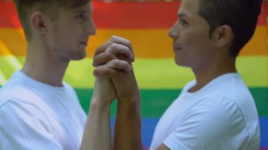 Erkek aşık yakınlık, zevk lgbt bayrak arka plan, el ele tutuşarak kabul