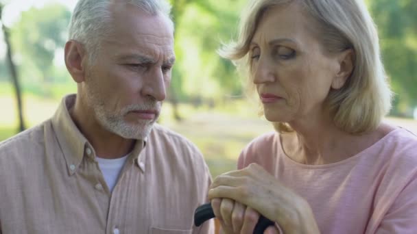 サポート 共感の概念 杖に手を繋いでいる動揺の老夫婦 — ストック動画