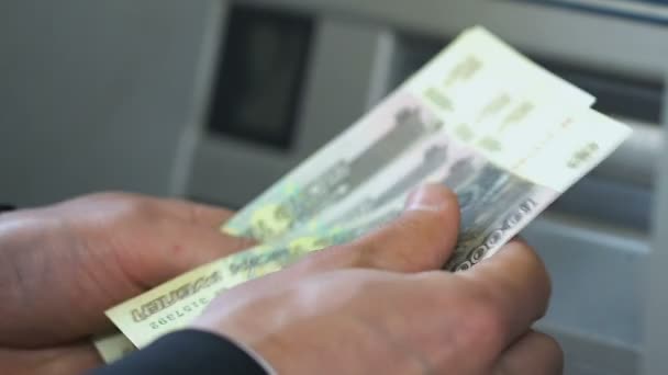 Руки Бизнесмена Подсчитывающего Российские Рубли Возле Банкомата Кладущего Деньги Бумажник — стоковое видео