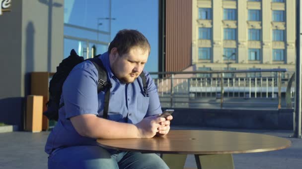 Gros Jeune Homme Défilement Smartphone Assis Dans Café Plein Air — Video