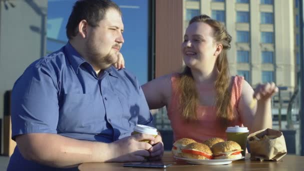 笑顔の女性治療彼氏フライド ポテト 脂肪夫婦の日付 不健康な食品 — ストック動画