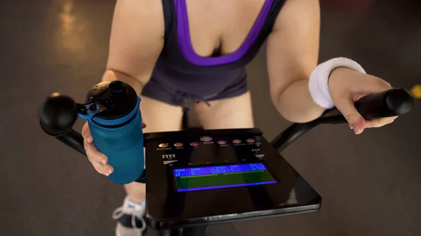 骑自行车和饮水 健身和保健的肥胖妇女 — 图库照片
