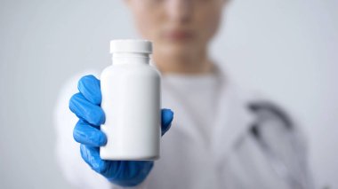 Büyük kavanoz içinde vitamin zengin beslenme takviyeleri, tutan kadın uzmanı