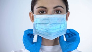 Kadın doktor cerrahi yüz maskesi yakın çekim, profesyonel tıbbi bakım, güven