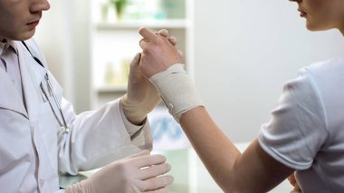 Erkek doktor işleme ilk yardım, kadının Burkulan bileği hastanede sarmak