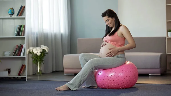 Onun Babys Dayak Dinleme Fitness Topu Üzerinde Oturan Sportif Hamile — Stok fotoğraf