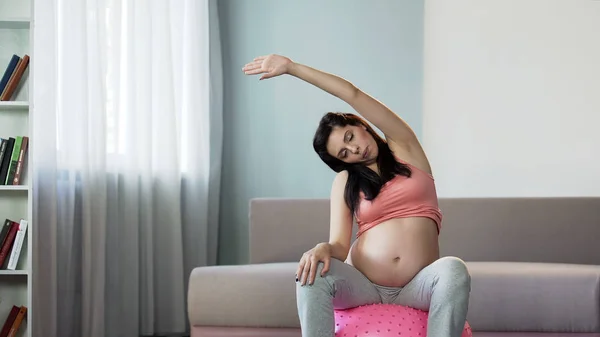 女人在怀孕期间做瑜伽改善循环和语调的肌肉 — 图库照片