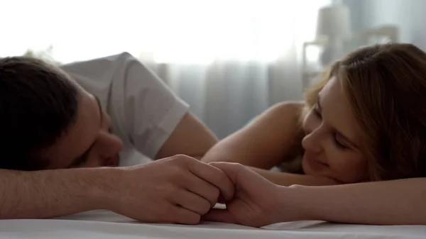 甜蜜的情侣用爱看着对方 牵着手在床上 — 图库照片