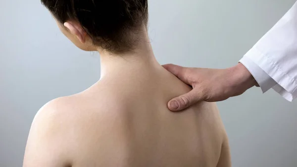 Specialist examining female back, holding her shoulder, scoliosis treatment — Stock Image Specialist Examining Female Back Holding Her Shoulder Scoliosis Treatment Stock Image