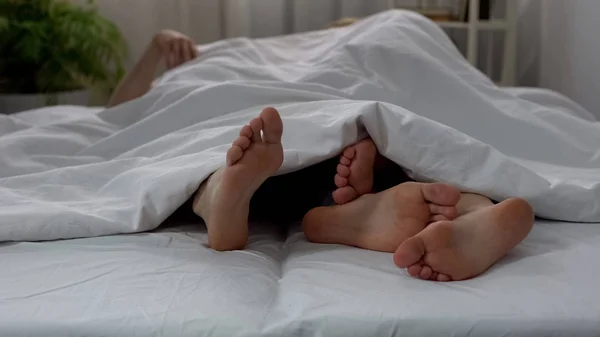 夫妇的腿做爱在床上看到毯子下 夫妇亲密关系 — 图库照片