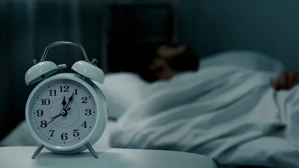 Uomo Che Dorme Letto Sveglia Che Mostra Mezzanotte Ore Riposo — Foto Stock