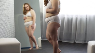 Vücut aynaya bakarak üzgün obez erkek göbek, Doğum çatlakları kontrol