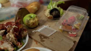 Disgusting dirty plates full of unhealthy food leftovers after student party clipart