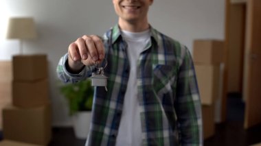 Man showing key from apartment, affordable lending, investment in real estate clipart