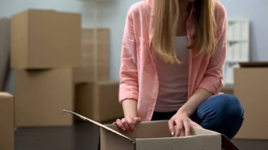 Girl unboxing stuff in new apartment, buying property, start of independent life clipart