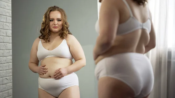 不开心的超重女士穿着内衣看镜子 感到羞愧的超重 — 图库照片