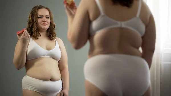 Mulher Deprimida Odiando Seu Corpo Gordo Comendo Perto Espelho Falta — Fotografia de Stock