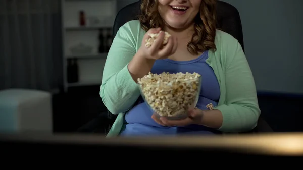 太りすぎの女性自宅のテレビ番組を楽しんで 座りがちな生活塩味ポップコーンを食べて — ストック写真