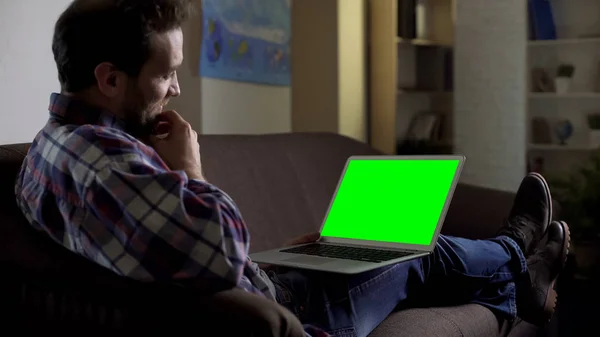 Чоловік Сидить Дивані Використовує Ноутбук Зеленим Екраном Спілкуючись Сайті — стокове фото