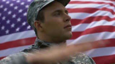 Gün ödüllendirici Amerikan bayrağı arka planda, tek tip saluting içinde askeri adam