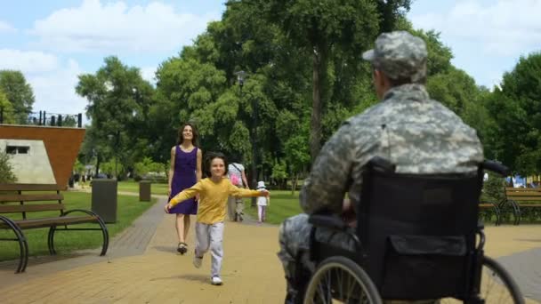 愉快的儿子拥抱父亲在轮椅受伤的士兵会议家庭返校节 — 图库视频影像