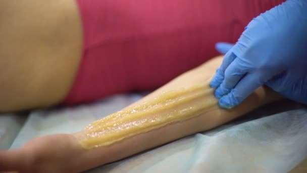 Trabajador Del Centro Spa Aplicando Pasta Azúcar Brazo Femenino Procedimiento — Vídeos de Stock