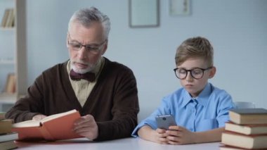 Okuma ve torunu telefonda, eğlence oyunları oynamak bakarak komuta sizde