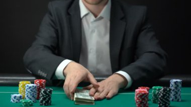 Şanslı casino kazanan doları banknot, masa etrafında, oyun ödül yongaları tutan